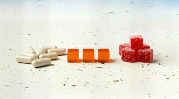 Comparison of white supplement capsules, orange lozenges, and red gummy candies on a white surface.