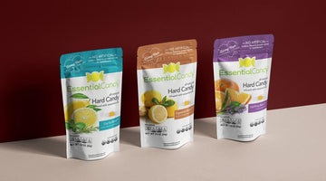 Three colorful bags of EssentialCandy Hard Candy in blue, orange, and purple packaging.