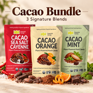 Three bags of Essential Candy Cacao Bundle hard candy are displayed on a wooden surface with chocolate pieces, cocoa powder, sliced oranges, and mint leaves. The bags are labeled Cacao Sea Salt Cayenne (red), Cacao Orange (cream), and Cacao Mint (green), with the text 'Cacao Bundle' and '3 Signature Blends' at the top.
