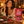Load image into Gallery viewer, A woman in a cozy indoor setting enjoys a piece of chocolate next to a red bag of Essential Candy Cacao Sea Salt Cayenne plant-powered hard candy. The table is styled with chocolate pieces, cacao nibs, sea salt, and chili peppers.
