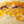 Load image into Gallery viewer, Yellow cube-shaped candies on a reflective surface with blurred orange slices in the background.
